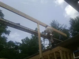 Carpenter setting a ridge beam over a new addition frame — Ice Dam Removal by Roofing Brothers in Laguna Woods
