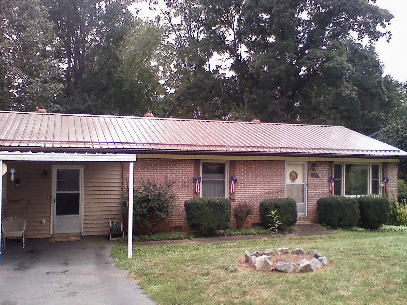 Bronze metal roof and carport on a brick ranch home — Roof Repair work by our crew in Laguna Woods
